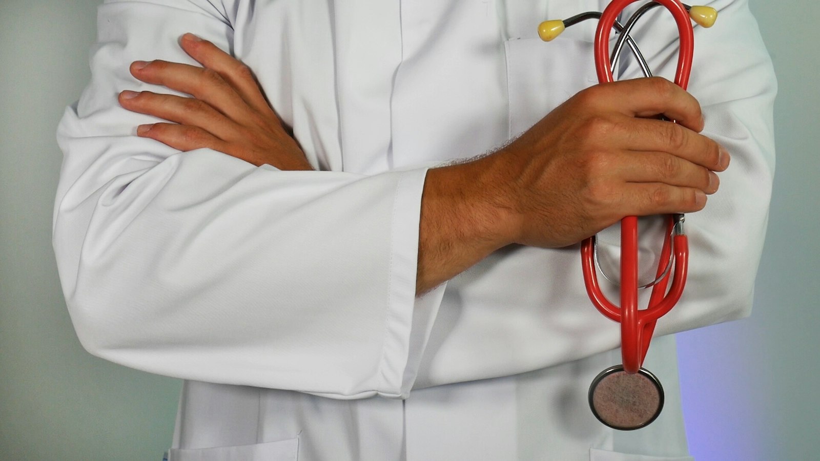 Médico de jaleco segurando um estetoscópio