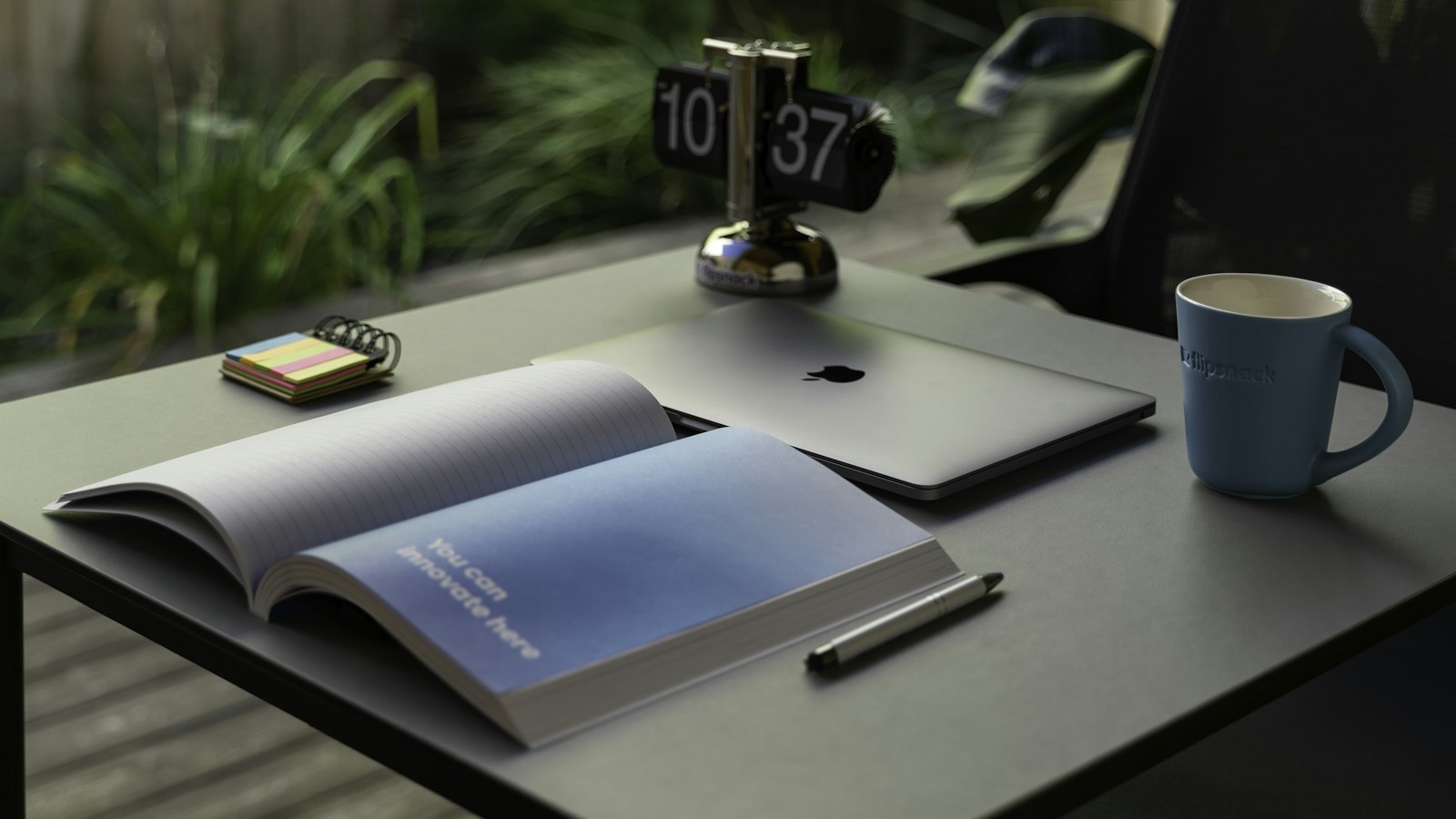 Mesa de trabalho com relógio, caderno e caneca