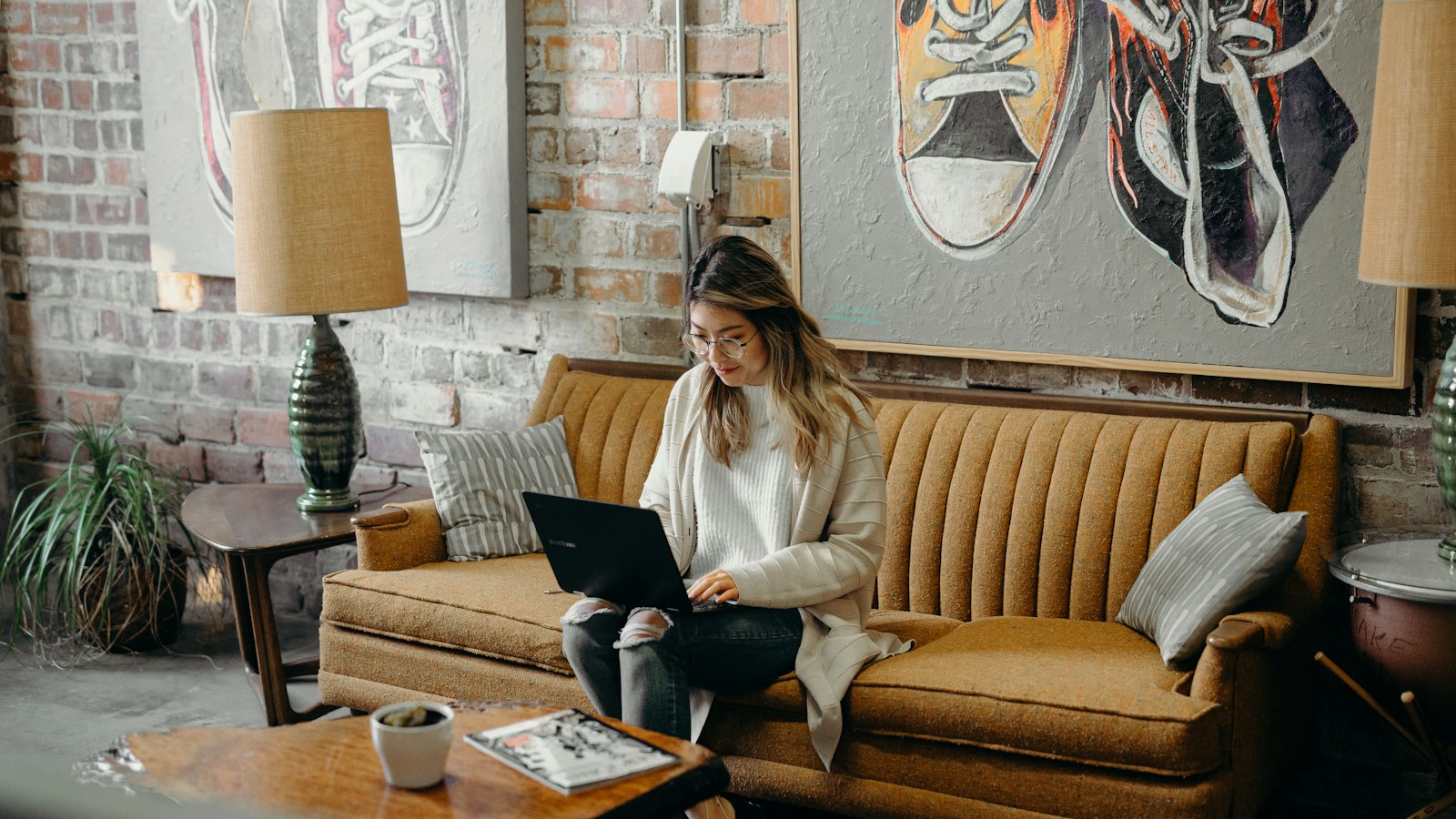 Mulher no sofá com notebook e papéis