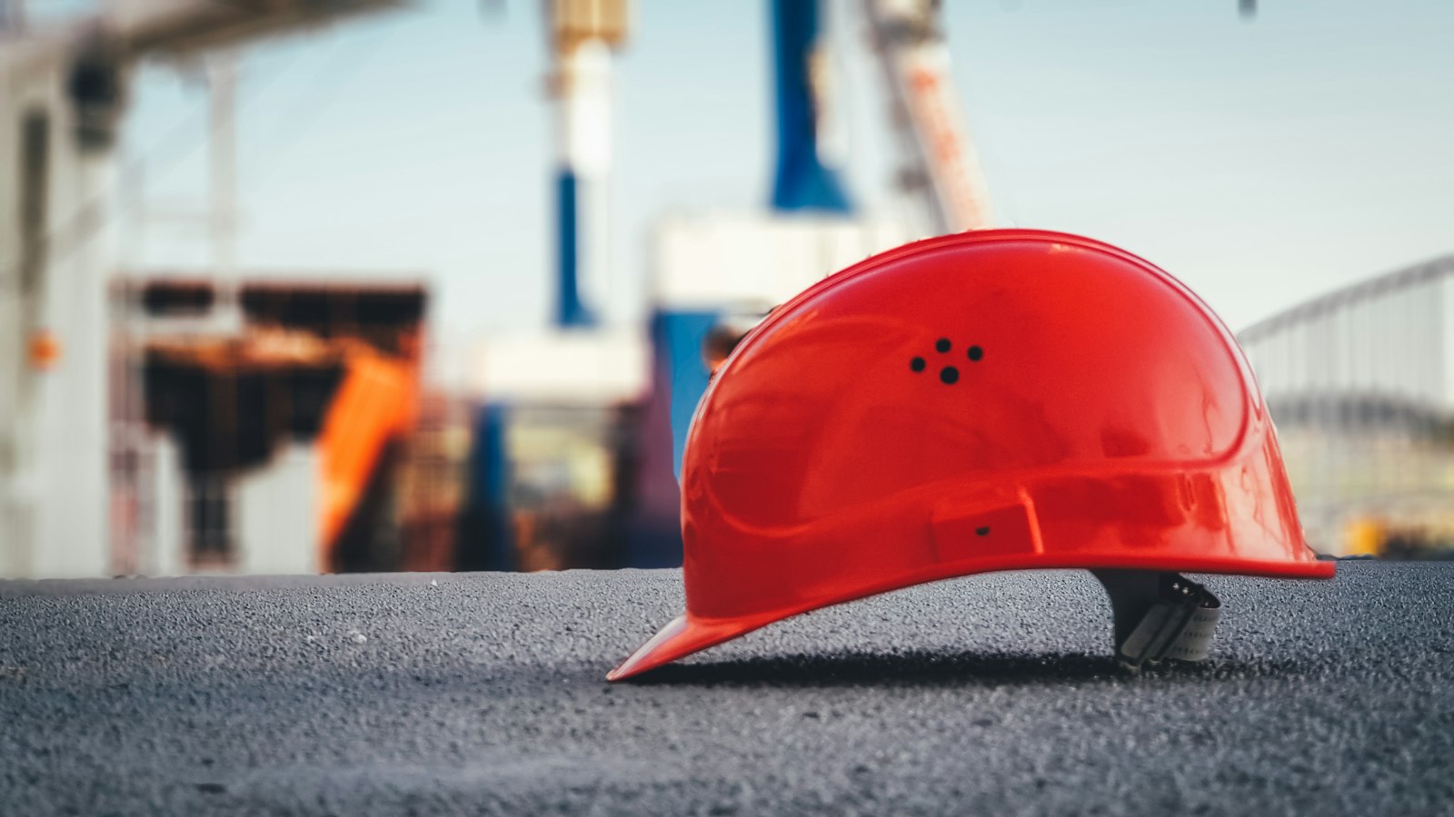 Capacete de segurança vermelho no chão de uma obra