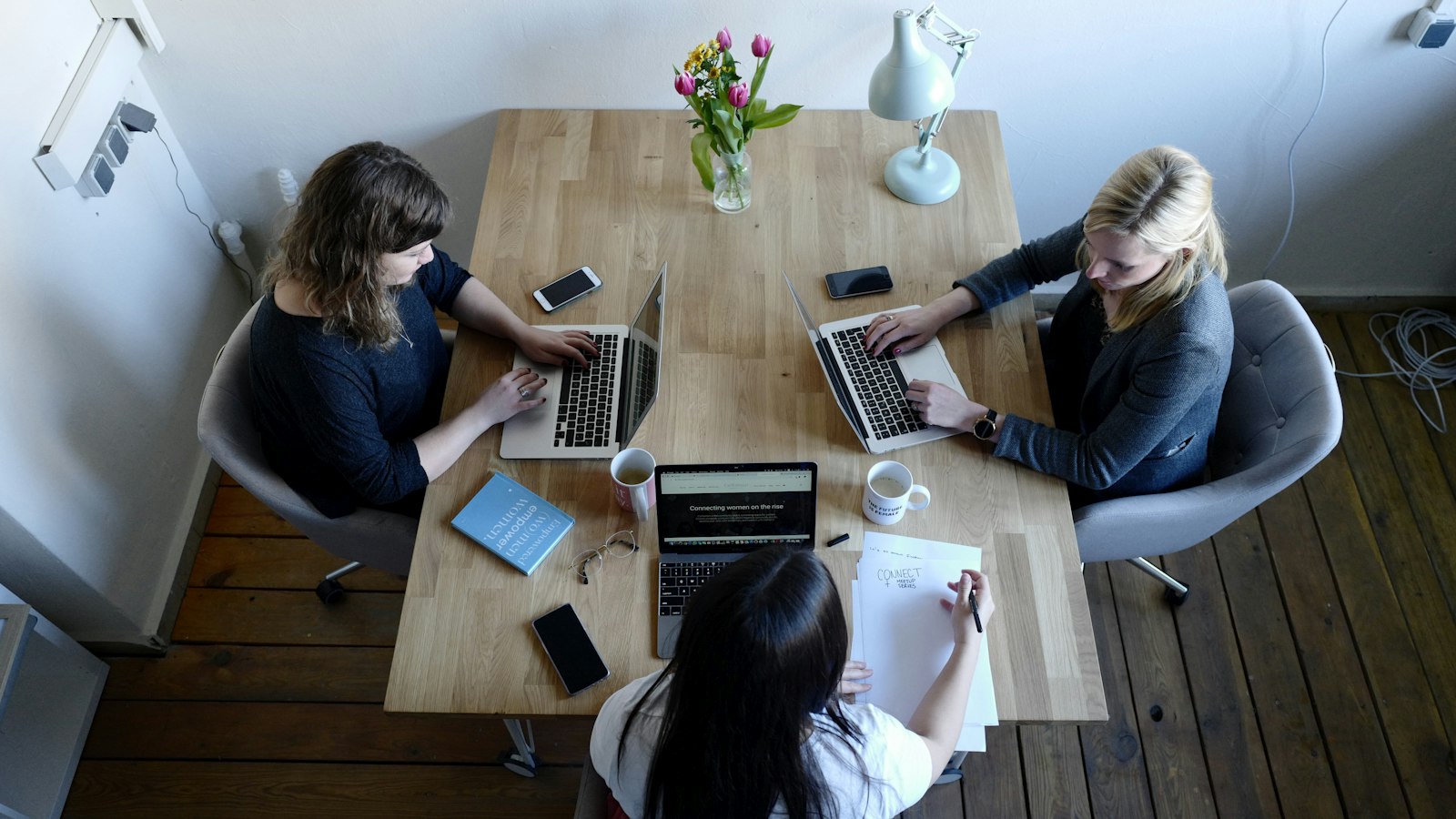 Reunião de trabalho em volta de uma mesa de madeira