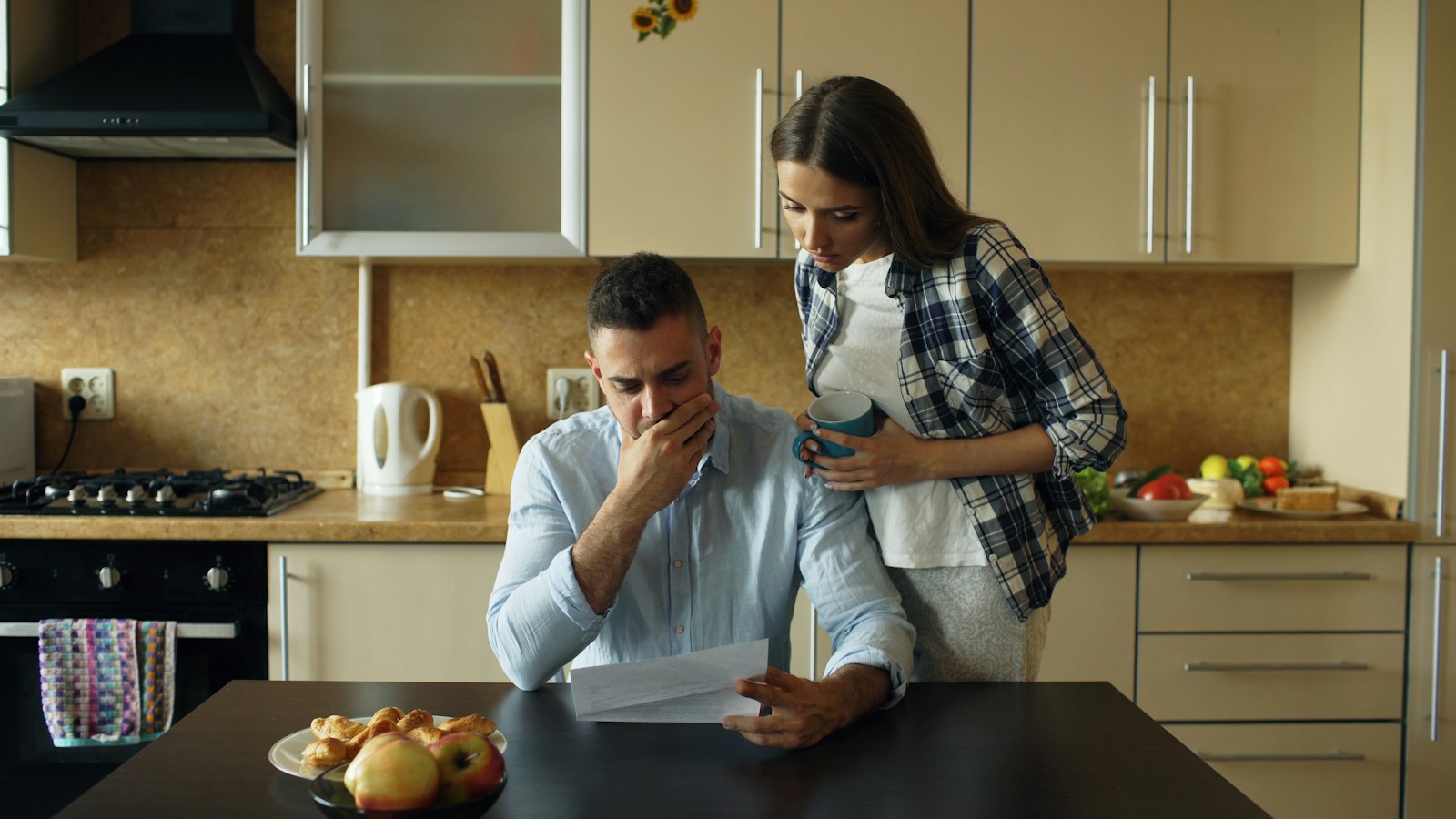 Casal conferindo contas na cozinha