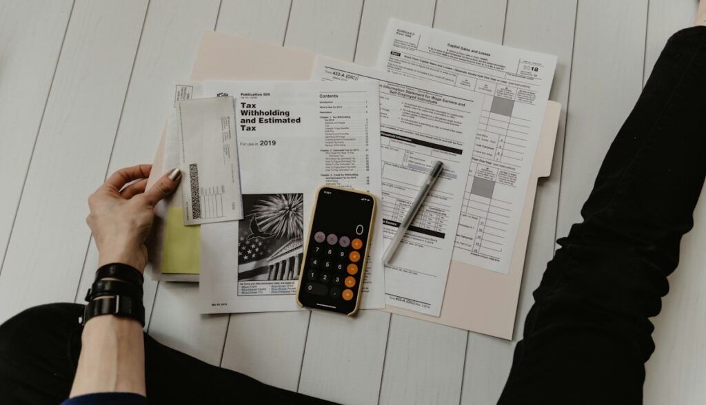 Pessoa conferindo contas e boletos com uma calculadora antes de contratar um empréstimo pessoal