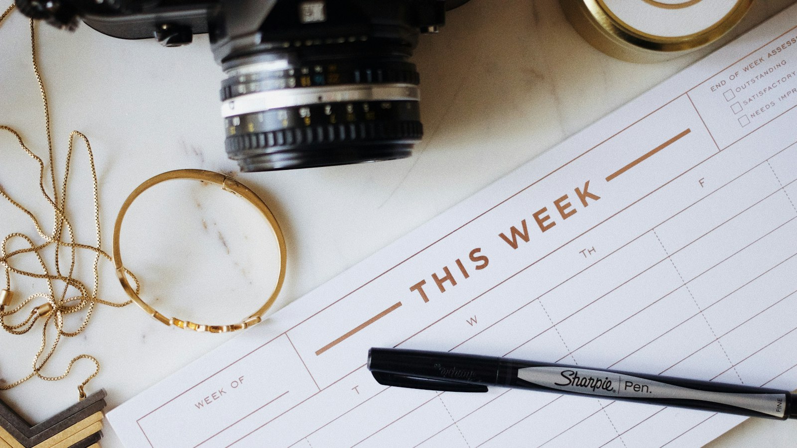 Planner semanal aberto com caneta para montar a escala