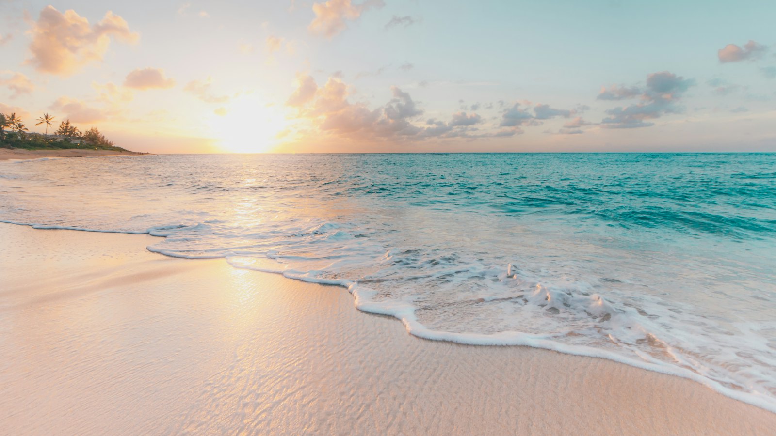 Praia com mar calmo ao pôr do sol