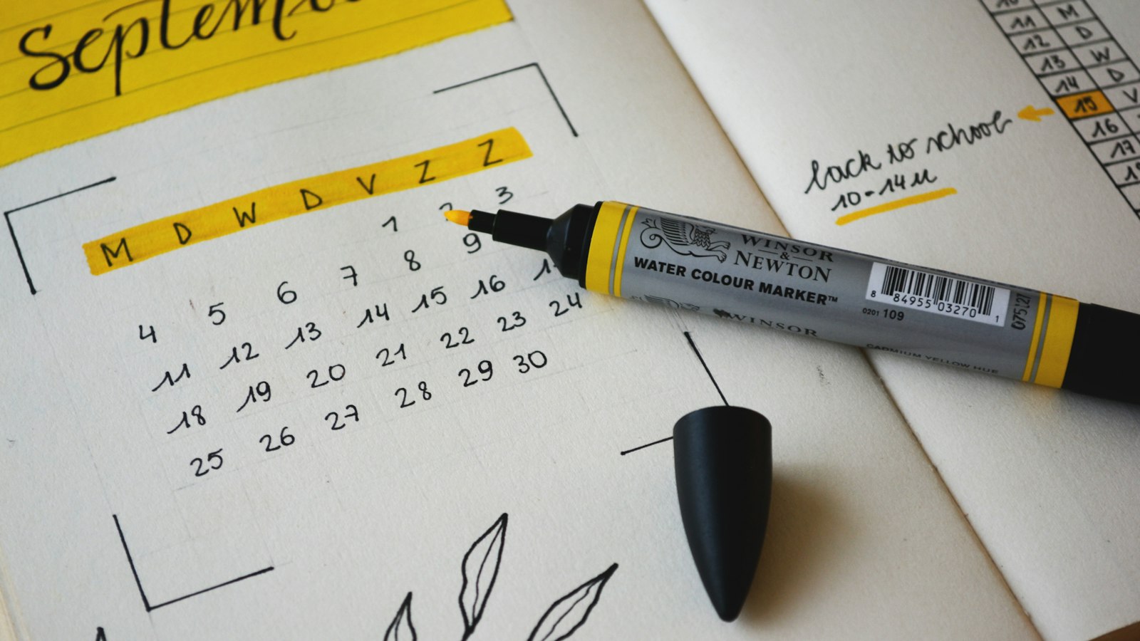 Calendário de planejamento e marcador sobre o caderno