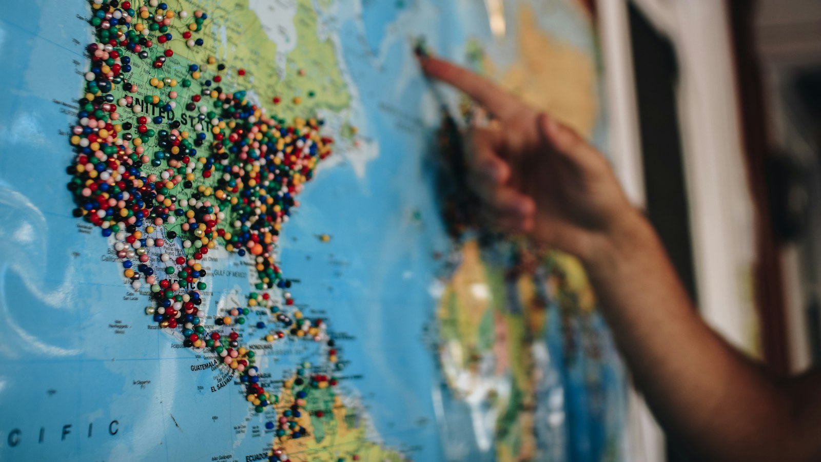 Pessoa apontando destinos de viagem em um mapa