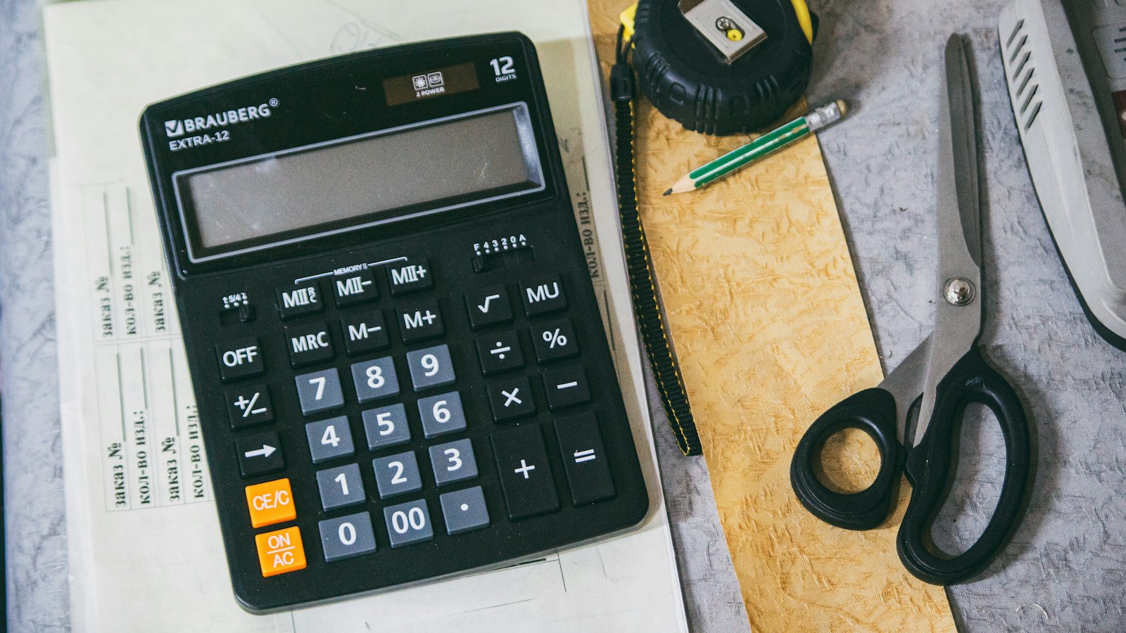 Calculadora e material de escritório sobre a mesa