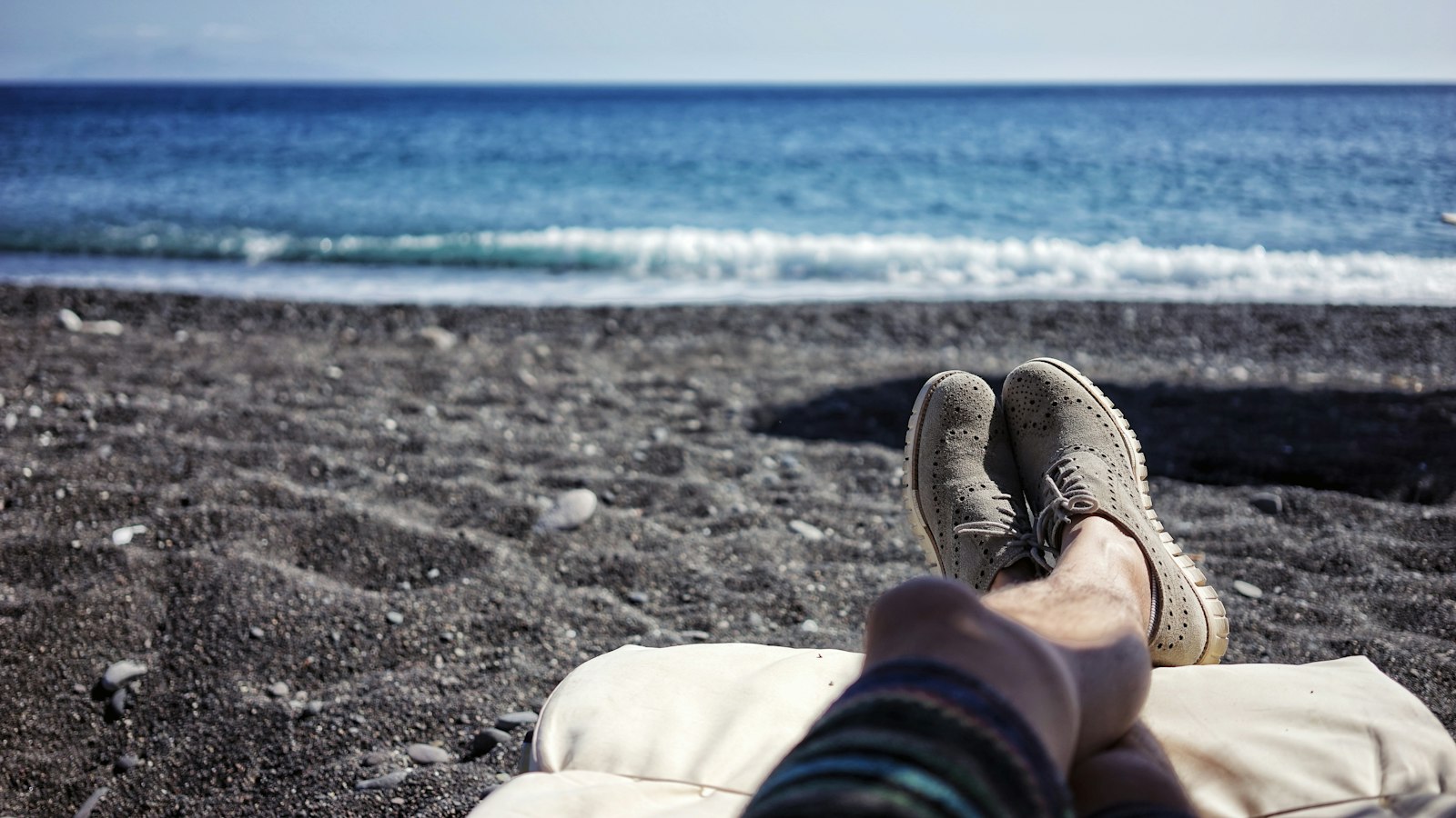Pessoa descansando com os pés para cima na praia