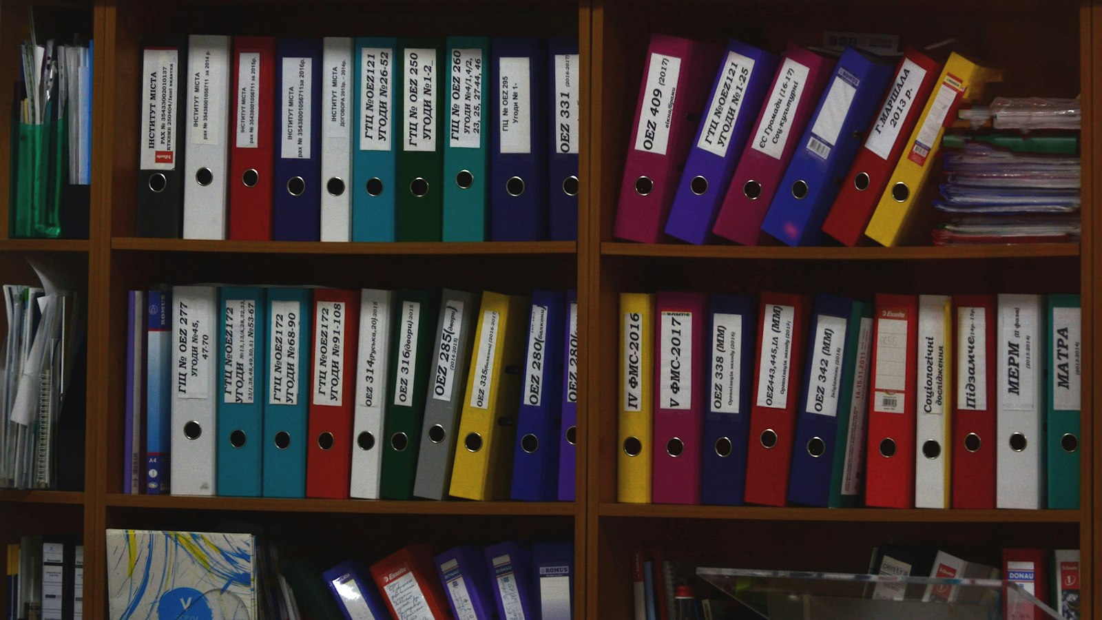 Estante com pastas de documentos coloridas e etiquetadas