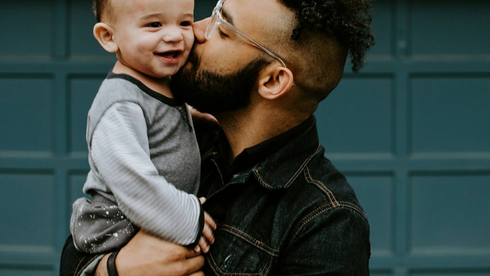 Pai segurando o filho pequeno no colo