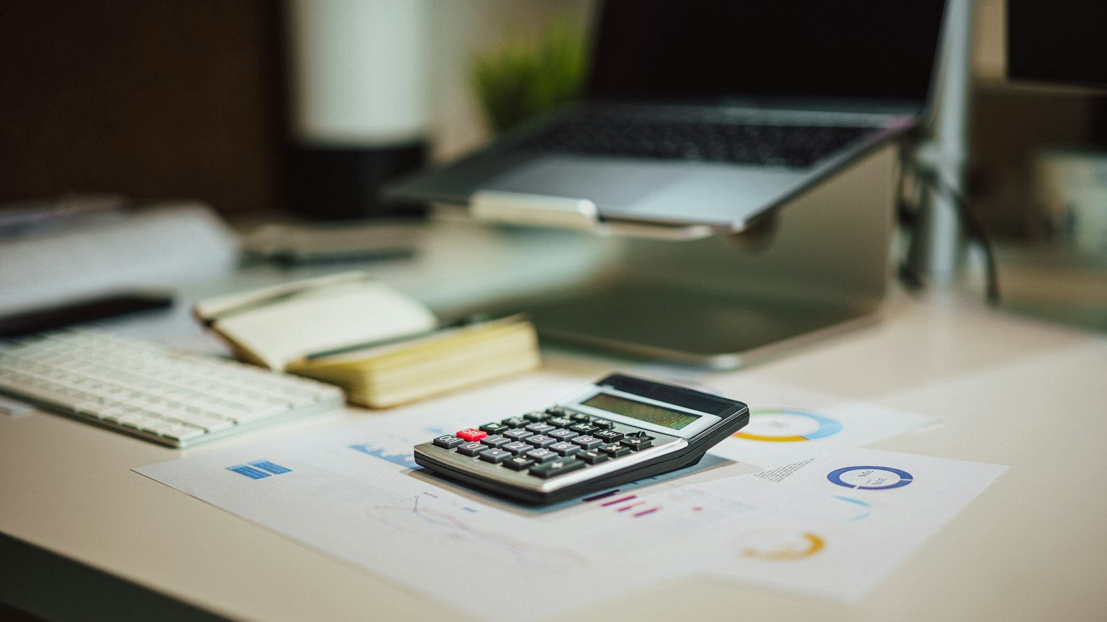 Mesa com notebook, calculadora e documentos