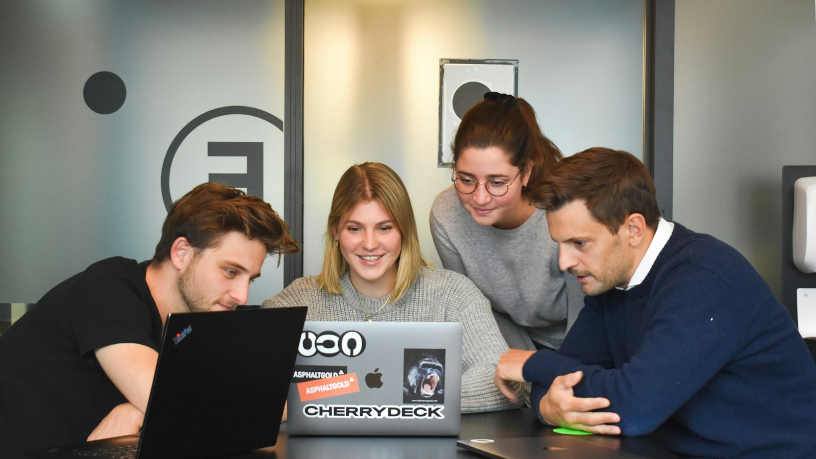 Equipe reunida em volta de um notebook no escritório