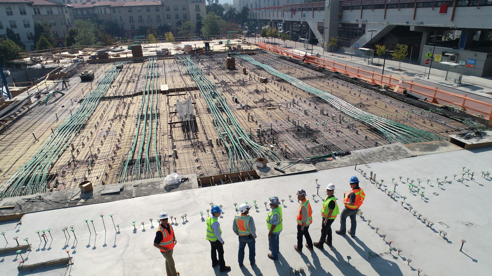Trabalhadores com capacete e colete em um canteiro de obras
