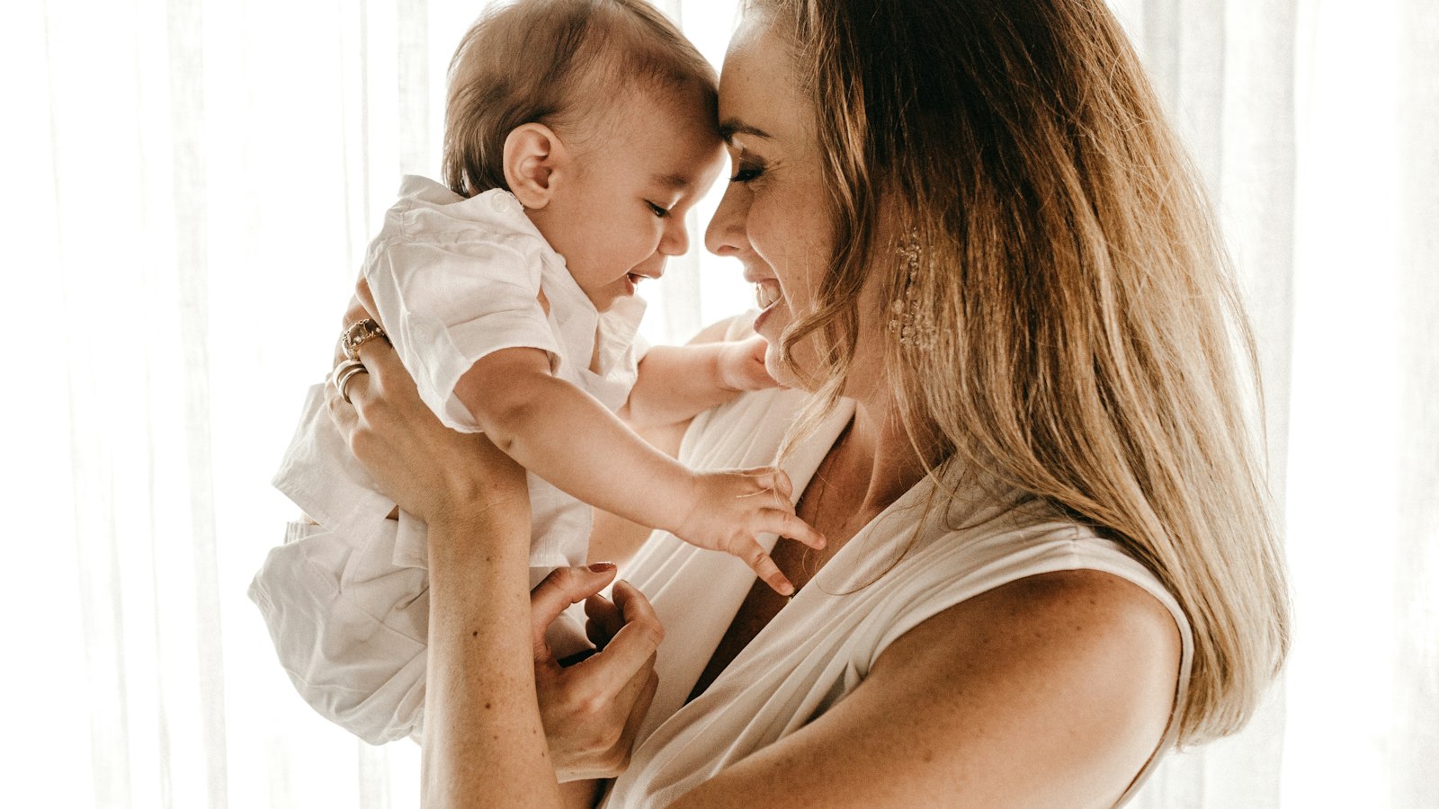 Mãe sorridente segurando o bebê no colo