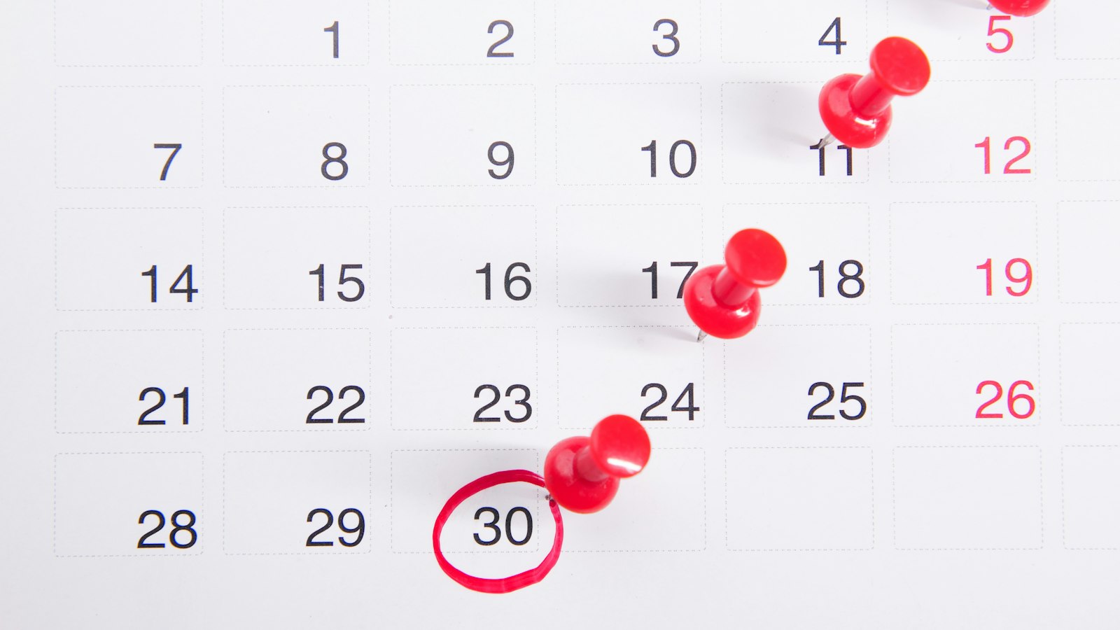 Calendário com dia marcado e prazos sinalizados com alfinetes