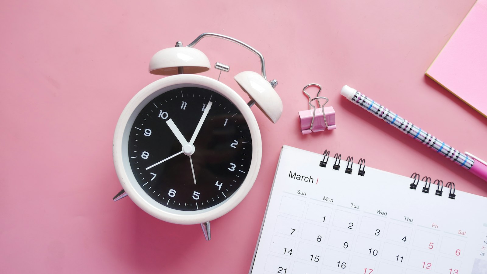 Despertador ao lado de um calendário