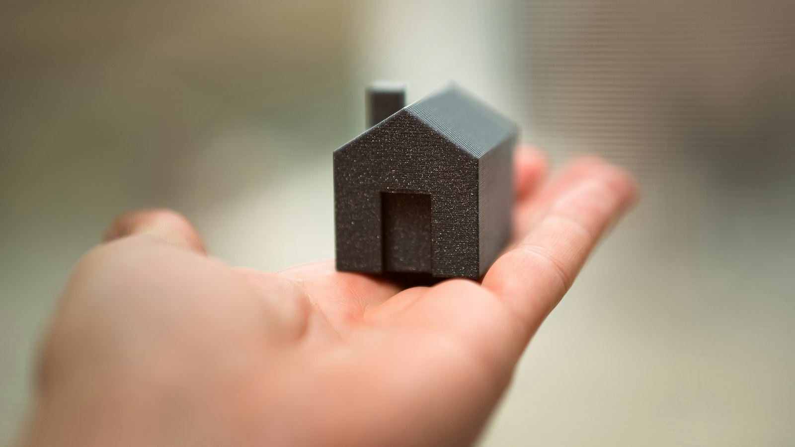 Miniatura de casa na palma da mão