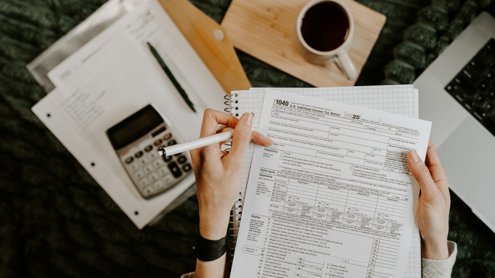 Mulher preenchendo planilhas com calculadora