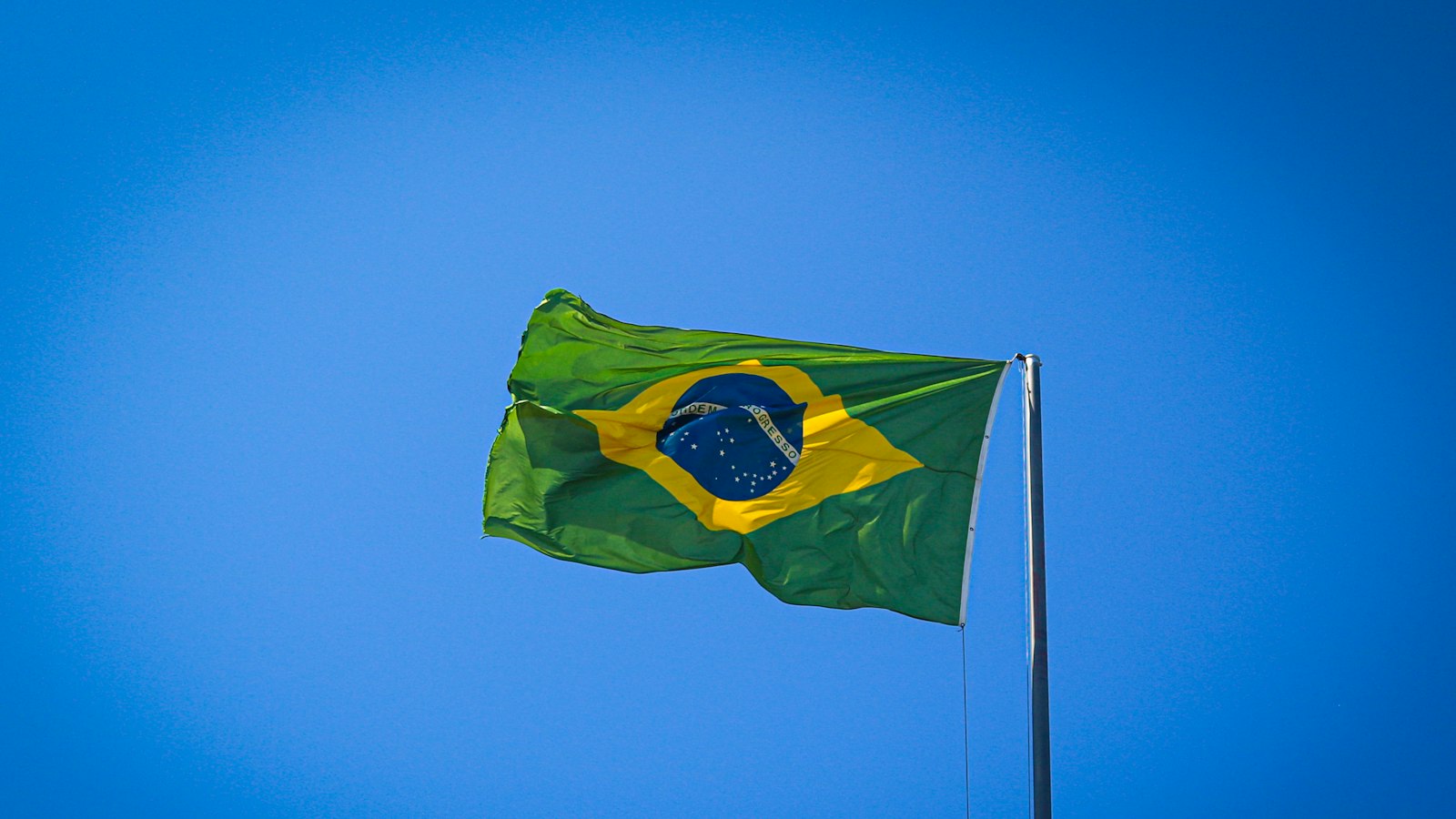 Bandeira do Brasil tremulando contra o céu azul